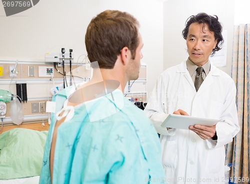 Image of Doctor Holding Digital Tablet While Discussing Report With Patie