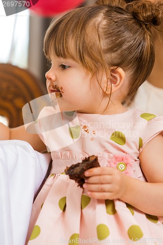 Image of Girl Eating Cake With Icing On Her Face