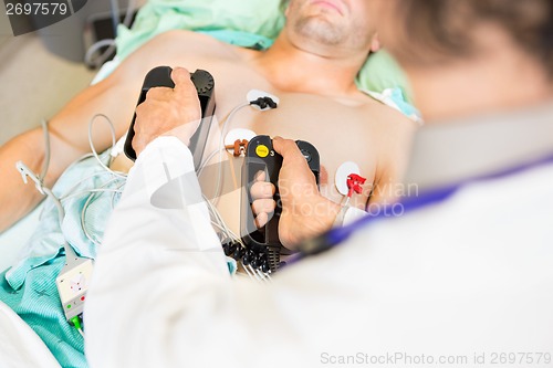 Image of Doctor Defibrillating Male Patient In Hospital