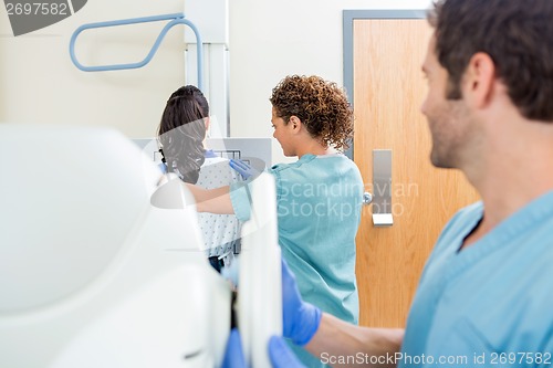 Image of Nurse Adjusting Xray Machine In Examination Room