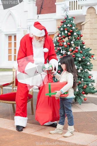 Image of Girl Taking Presents From Santa Claus