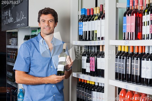 Image of Man Holding Bottle Of Alcohol At Supermarket