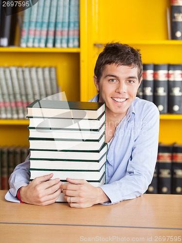 Image of Student Sitting With Piled Books In University Library
