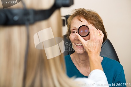 Image of Optician Examining Senior Woman's Eye