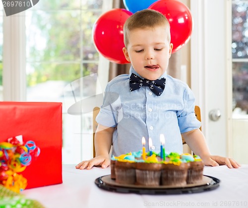 Image of Birthday Boy Licking Lips While Looking At Cake