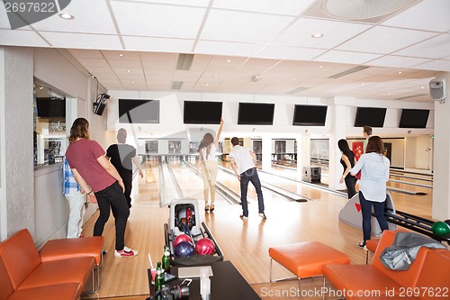 Image of Young Friends Bowling in Club