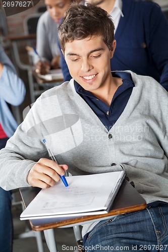 Image of Student Looking At Exam Paper In Classroom