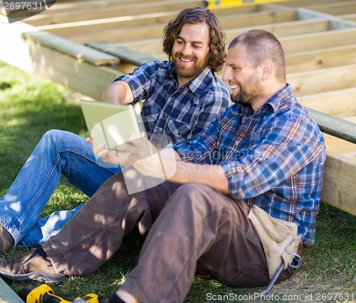 Image of Happy Carpenters Using Digital Tablet At Construction Site