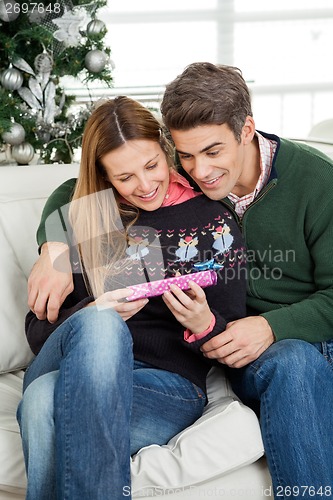 Image of Smiling Couple Looking At Christmas Gift