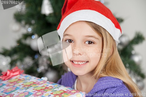 Image of Girl Wearing Santa Hat With Christmas Gift