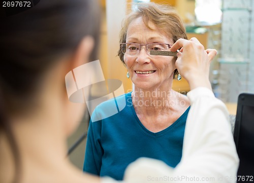 Image of Female Optician Measuring Woman's Eyeglasses