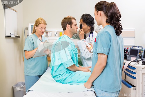 Image of Medical Team Examining Patient In Hospital