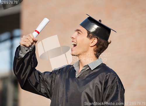 Image of Student Holding Diploma On Graduation Day In College