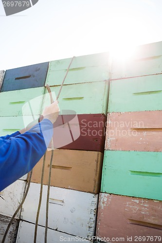 Image of Beekeeper Tying Rope On Stacked Honeycomb Crates