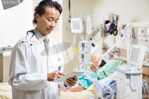Image of Doctor Examining Patient's Report On Digital Tablet