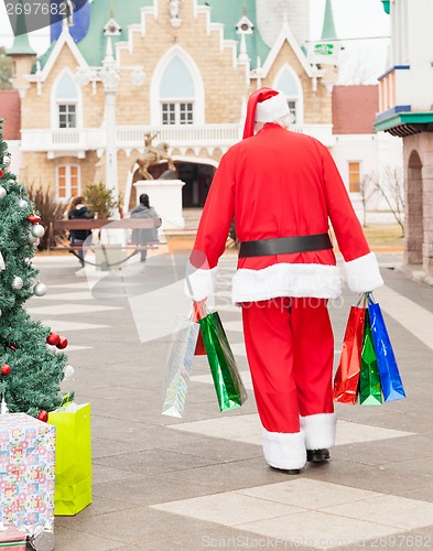 Image of Santa Claus With Bags Walking In Courtyard
