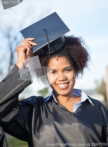 Image of Woman In Graduation Gown Wearing Mortar Board On Campus