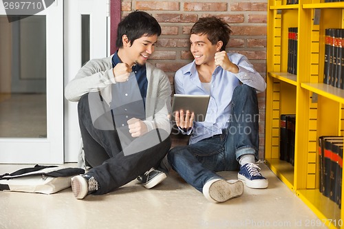 Image of Students With Digital Tablet Clenching Fist While Sitting In Lib