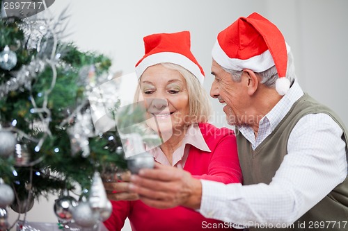 Image of Senior Couple Decorating Christmas Tree