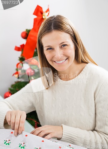 Image of Happy Woman Wrapping Christmas Present