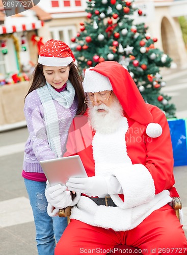 Image of Santa Claus And Girl Using Digital Tablet