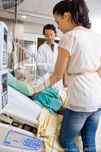 Image of Woman And Doctor Looking At Critical Patient