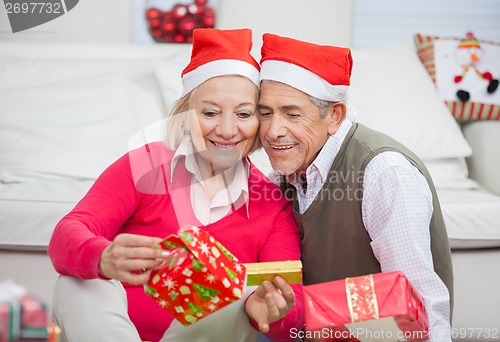 Image of Loving Couple Looking At Christmas Gifts