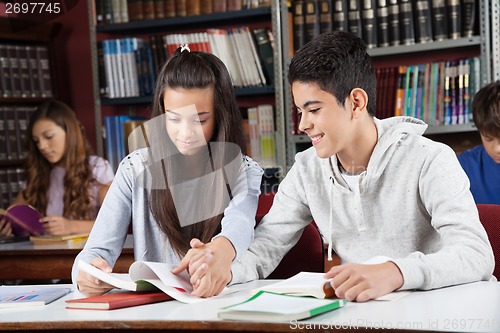 Image of Friends Studying Together While Holding Hands At Desk