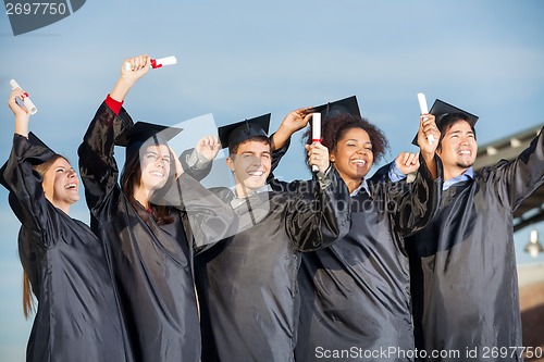 Image of Students Holding Certificates Against Sky