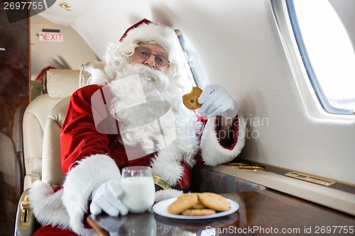 Image of Santa Having Cookies And Milk In Private Jet