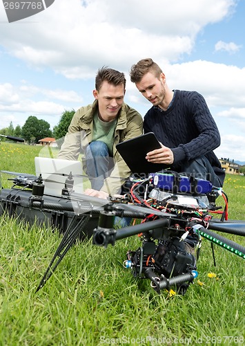 Image of Technicians Discussing Over Digital Tablet By UAV