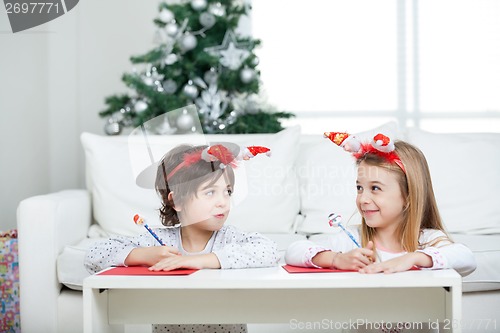 Image of Siblings Writing Letter To Santa Claus During Christmas