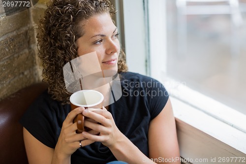 Image of Thoughtful Woman With Coffee Mug In Cafe