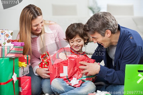 Image of Boy And Parents Opening Christmas Present