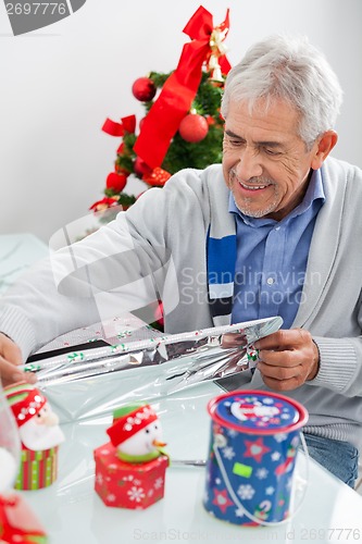 Image of Man Wrapping Christmas Present