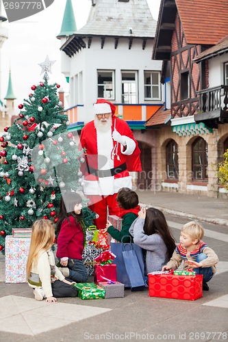 Image of Children With Gifts Looking At Santa Claus