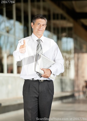Image of Confident Teacher With Books Gesturing Thumbsup On Campus
