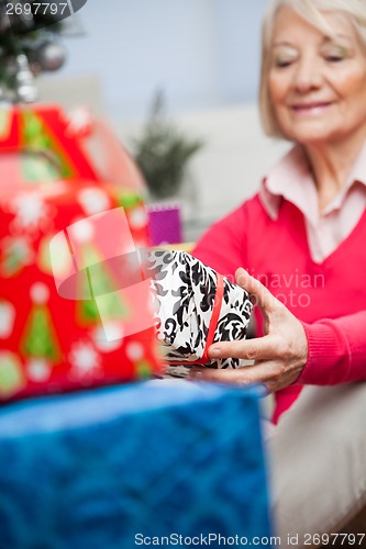 Image of Senior Woman Holding Christmas Present