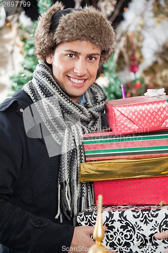 Image of Happy Man Carrying Stacked Gift Boxes