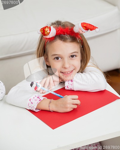 Image of Smiling Girl Making Christmas Greeting Card