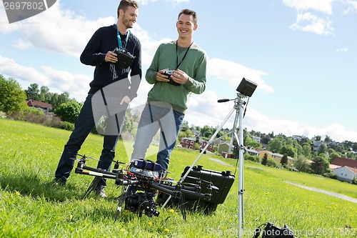 Image of Technicians Holding Remote Controls Of UAV