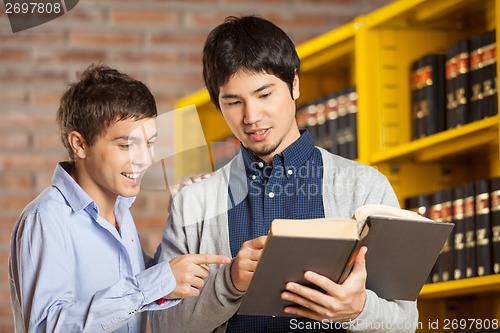 Image of Friends Reading Book In College Library