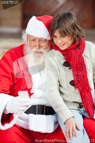 Image of Santa Claus And Boy Using Smartphone