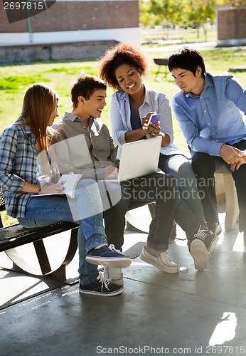 Image of Student Showing Mobilephone To Friends In Campus