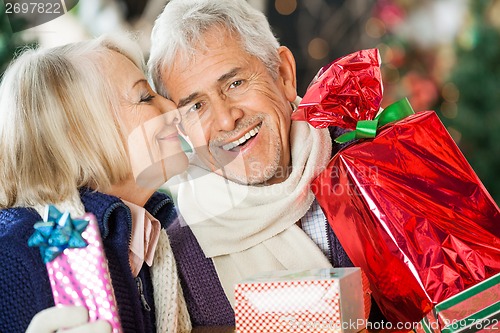 Image of Woman About To Kiss Man Holding Christmas Presents