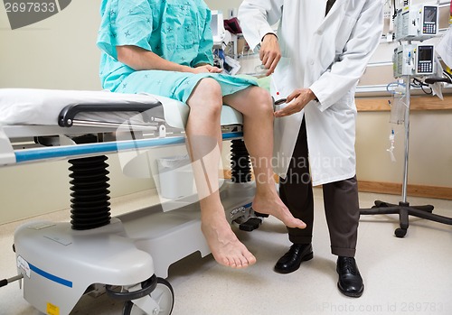 Image of Neurologist Examining Patient's Knee With Hammer In Hospital