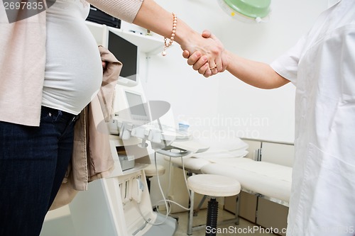 Image of Pregnant Woman And Doctor Shaking Hands