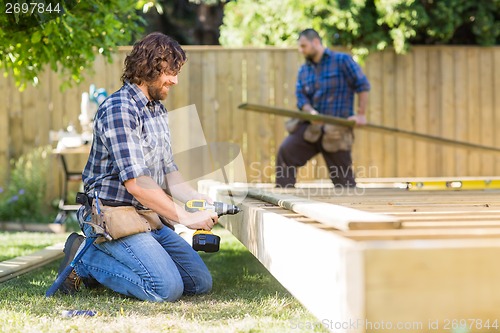 Image of Manual Worker Drilling Wood At Construction Site