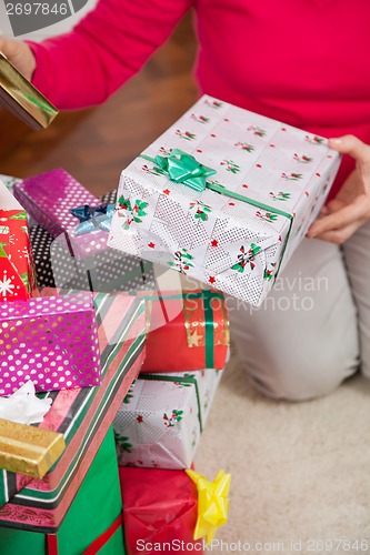 Image of Senior Woman Sitting By Christmas Gifts