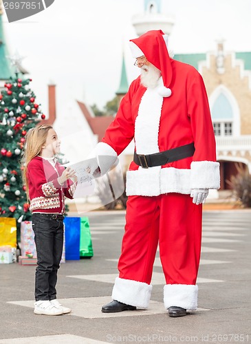 Image of Girl Giving Wish List To Santa Claus